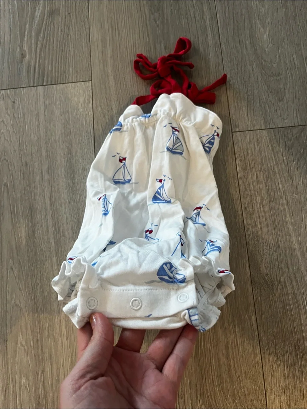 The Beaufort Bonnet Company White Romper with Blue Sailboats and Red Tie Straps